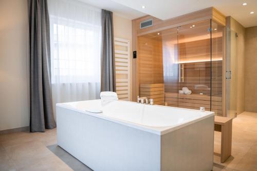 a large bathroom with a tub and a shower at Naturresort & Spa Schindelbruch in Stolberg i. Harz