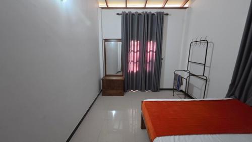 an empty room with a bed and a window at Kumara Guest House in Anuradhapura