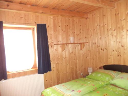 um quarto com uma cama verde e uma janela em Kinga House em Keszthely