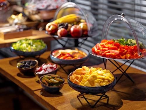 a table with bowls of different types of fruits and vegetables at Mamaison Residence Diana in Warsaw