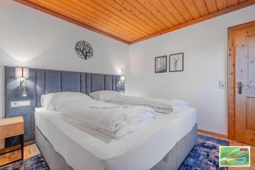 a large bed in a bedroom with a wooden ceiling at Appartements Spitzegel in Hermagor