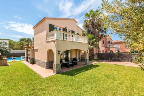 a house with a balcony and a yard at Villa Laurax in Son Carrio