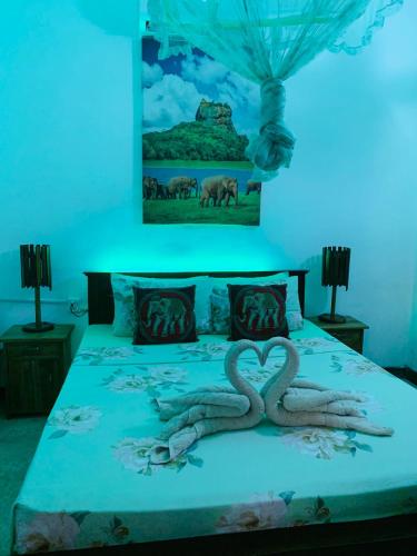a bed with two snakes forming a heart on it at Dhona's Villa in Sigiriya