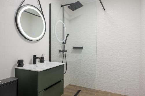 a bathroom with a sink and a shower with a mirror at 1001 Central Riverside Flat in Bucharest