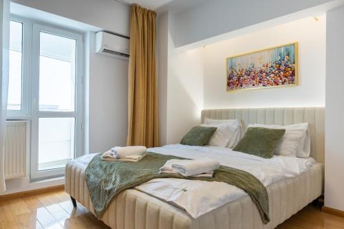 a bedroom with a bed with two towels on it at 1001 Central Riverside Flat in Bucharest