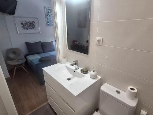 un bagno con lavandino, WC e specchio di Sitges BnB Deluxe Rooms a Sitges