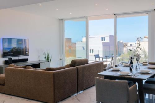 a living room with two couches and a table at Villa Ixoria Unit 2 w Rooftop Pool by Arco Collection in St. Julianʼs