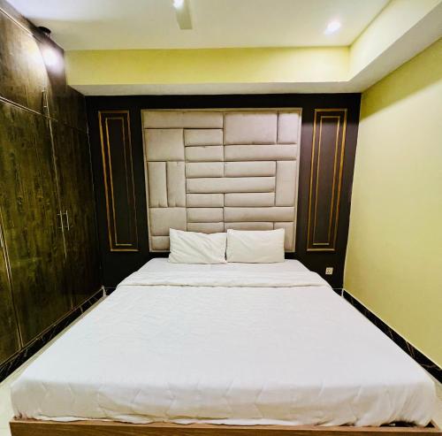 a bedroom with a large white bed in a room at Modern 2-Bedroom Apartment Only For Families in E-11 Northern strip in Islamabad