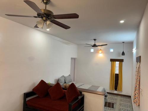 にあるPhalguni Farm Stayのリビングルーム(天井ファン、ソファ付)