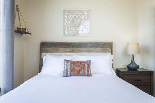 a bedroom with a white bed with a wooden headboard at Summit House Joshua Tree Iconic Mountain Estate with Spa Ping-Pong Pool Table Fire Pit in Yucca Valley