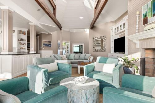 a living room with blue furniture and a fireplace at Malibu Dunes by Fieldtrip Expansive Hamptons-Style Estate w Private Beach Backyard in Malibu