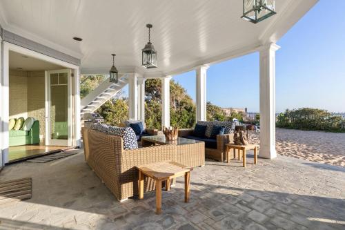 an outdoor patio with couches and a table and chairs at Malibu Dunes by Fieldtrip Expansive Hamptons-Style Estate w Private Beach Backyard in Malibu