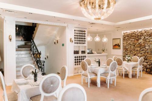 a restaurant with white tables and chairs and a staircase at Golden Hotel in Pristina