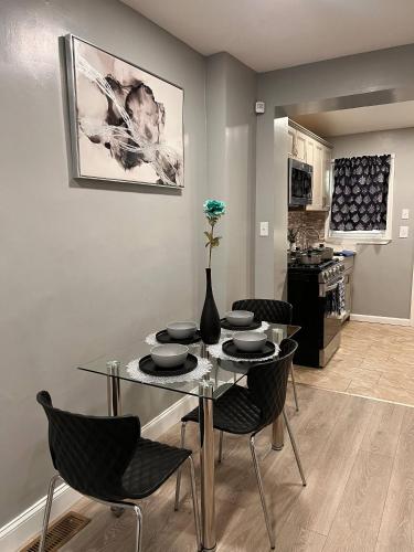 a dining room with a glass table and chairs at Cozy Modern Home with Large Fenced in Backyard in Camden