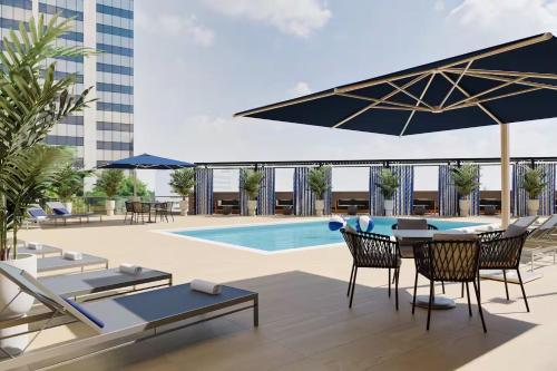 a patio with a table and chairs and a pool at Luxury Apartments by Hyatus White Plains in White Plains