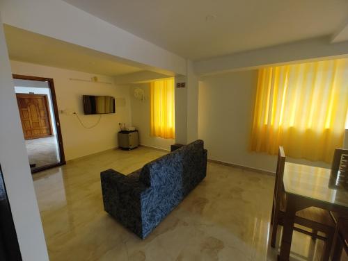 a living room with a couch and a table at Rajdhani Hospitality in Kazhakuttam
