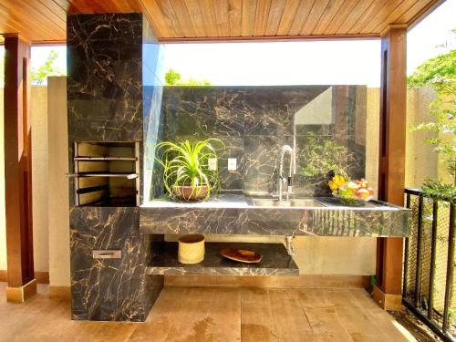 a kitchen with a sink and a window at Lindo Flat Garden beira-lago e perto da praia in Camaçari