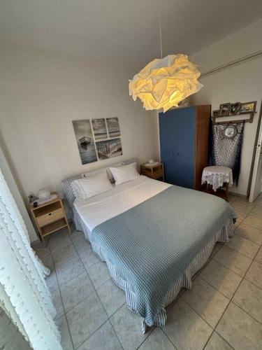 une chambre avec un grand lit et un lustre dans l'établissement Villa Dina, à Paralia Dionisiou