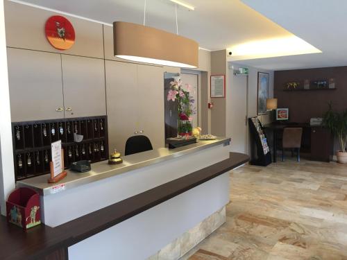 a salon with a counter with a flower in a window at Atalante in Annemasse