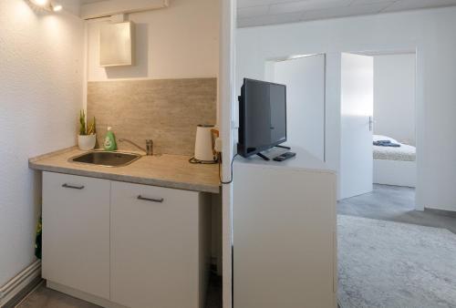 a kitchen with a sink and a tv on a refrigerator at Ferienwohnung mit Schlossblick Wernigerode in Wernigerode