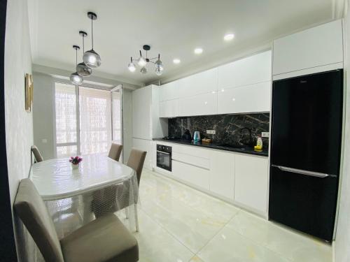 eine Küche mit einem Esstisch und einem schwarzen Kühlschrank in der Unterkunft Apartament Chisinau in Chişinău