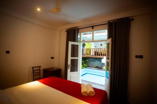 - une chambre avec un lit et une piscine à l'extérieur d'une fenêtre dans l'établissement Royal Rich Villa, à Unawatuna