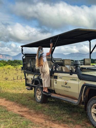 a woman standing on the back of a jeep at Honeyguide Conservation Lodge in Golders Green