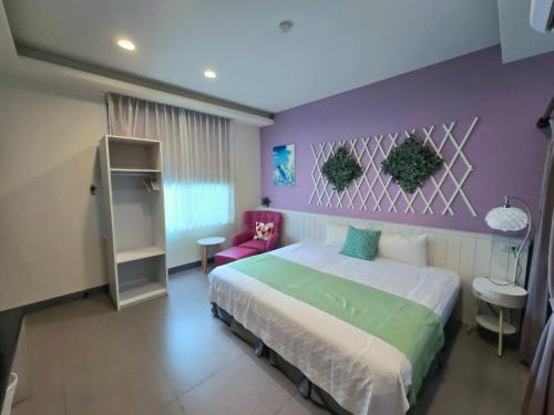 a bedroom with a bed and a purple wall at Bestime B&B in Jiji