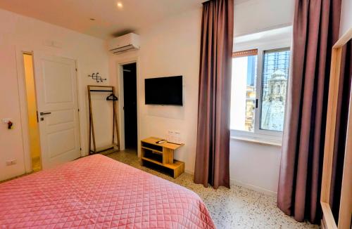 a bedroom with a bed and a window and a television at Incoming Municipio in Naples