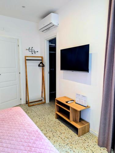 a bedroom with a bed and a tv on a wall at Incoming Municipio in Naples