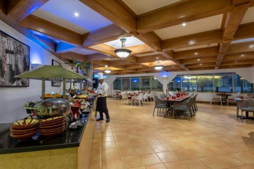 a chef standing at a buffet in a restaurant at Atana Khasab Hotel in Khasab