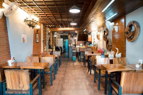una fila de mesas y sillas en un restaurante en Nature Home Hostel & Cafe, en Chiang Mai
