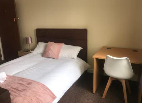 a bedroom with a bed with a desk and a chair at 34 - Room 1 - Uplands in Swansea
