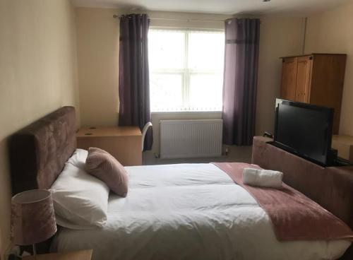 a bedroom with a large bed and a television at 34 - Room 1 - Uplands in Swansea