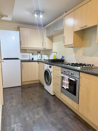 a kitchen with a white refrigerator and a dishwasher at Family home close to Shrewsbury Town centre in Shrewsbury