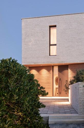 a house with a wooden door and a tree at Mondellebotte - Luxus Villa & traumhafter Meerblick in Barat