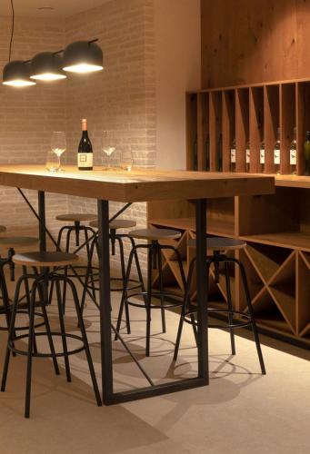 a table with chairs and a bottle of wine on it at Mondellebotte - Luxus Villa & traumhafter Meerblick in Barat