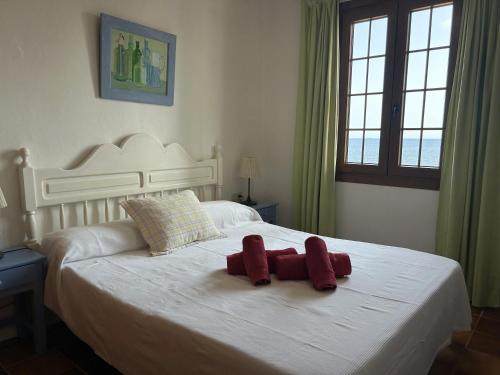 a bedroom with a bed with two stuffed animals on it at BERGANTIN 109 by SOM Menorca in Fornells