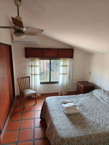 a bedroom with a bed and a chair and a window at Cabañas Akumali in Nono
