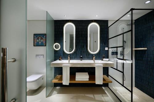 a bathroom with a sink and two mirrors at Hard Rock Hotel Marbella - Puerto Banús in Marbella