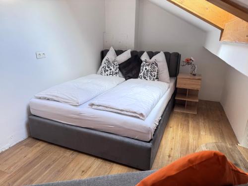 a black couch with pillows on it in a room at Alpin Apartments am Dorfbrunnen FAMILY SUITE in Steinach am Brenner