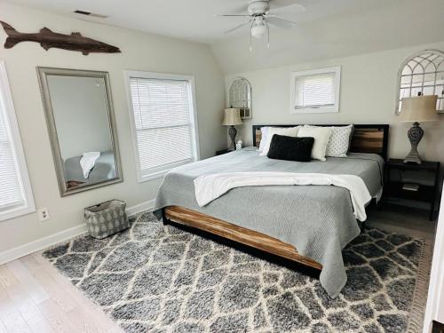 a bedroom with a bed and a fan and windows at coastal and cozy beach stay, pet friendly in Milford