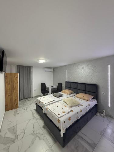 a bedroom with a large bed in a room with marble floors at Carigradski Drum Residence in Radinac