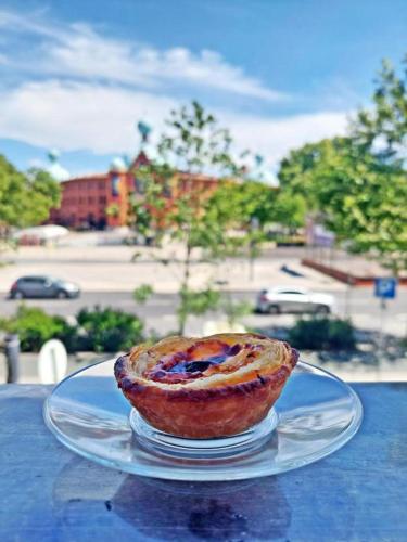 a pastry sitting on a glass plate on a table at Bella Lisboa in Lisbon