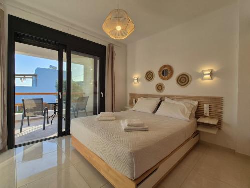 a bedroom with a bed with a view of a balcony at Villa Neroli Pool & Mountain Views in Pitsidia in Pitsidia