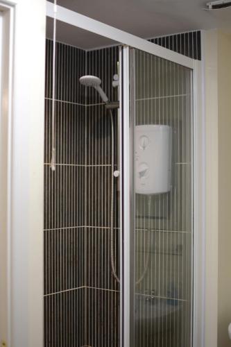 a shower in a bathroom with a glass door at Family home close to Shrewsbury Town centre in Shrewsbury