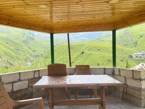 a table and two chairs on a porch with a view at Shahdag Boutique Hotel in Laza