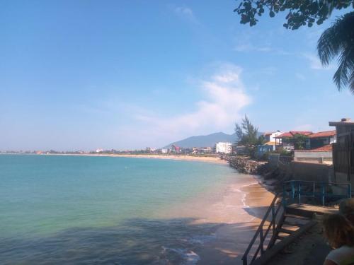 a view of a beach with a mountain in the background at Hostel casa amarela in Rio das Ostras