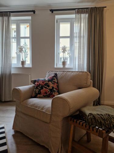 a living room with a couch and two windows at Mühlenloge 1819 in Perleberg