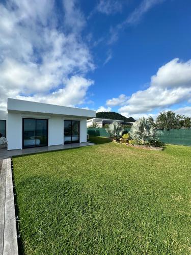 a white house with a large yard at Havre de paix luxueux avec vue mer imprenable in Dumbéa